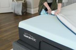 a person pulling the top off of a mattress